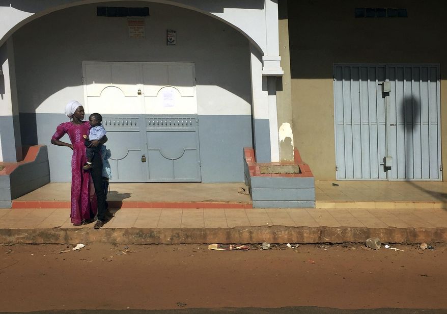 A woman looks down an empty street in Banjul, in Gambia, Wednesday Jan. 18, 2017. Special flights were being organized Wednesday to evacuate British and other tourists from Gambia, where the threat of a regional military intervention loomed as President Yahya Jammeh's mandate expires on Thursday after he lost elections in December. On Tuesday, he declared a state of emergency before he is supposed to cede power to President-elect Adama Barrow. (AP Photo)