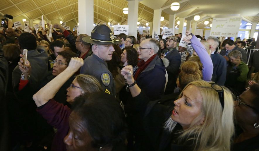 FILE- In this Dec. 15, 2016 file photo, demonstrators crowd the rotunda outside the House and Senate galleries during a special session at the North Carolina Legislature in Raleigh, N.C.  As North Carolina’s political split widens, state business is increasingly being refereed with a judge’s gavel.  There’s been a swarm of lawsuits filed as Democrats and their allies have turned to the courts to challenge laws approved by the Republican legislature.   (AP Photo/Gerry Broome, File)