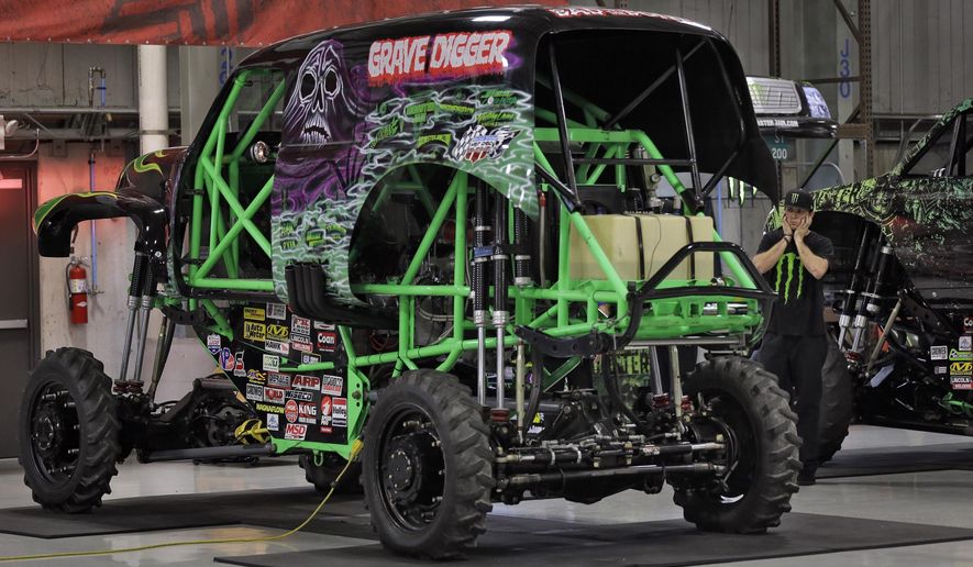 FILE - In this Nov. 25, 2014, file photo, Coty Saucier, far right, covers his ears as the monster truck "Grave Digger" gets its engine started at Feld Entertainment in Ellenton, Fla. Grave Digger driver Dennis Anderson was hurt in a crash at "Monster Jam" in Tampa, Fla. on Saturday, Jan. 14, 2017. (AP Photo/Chris O'Meara, File)