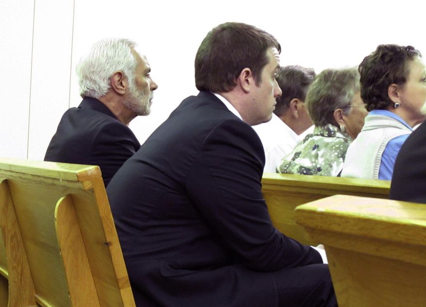 Suspended South Carolina Rep. Chris Corley, right, waits for a bond hearing with his lawyer, John Delgado, left, at the Aiken County courthouse in Aiken, S.C., on Wednesday, Jan. 18, 2016. A judge set a $50,000 bond for Corley on a more serious charge of domestic violence. Corley was originally charged with second-degree criminal domestic violence, but an Aiken County grand jury indicted the 36-year-old Republican earlier this month on the more serious charge of criminal domestic violence of a high and aggravated nature. (AP Photo/Jeffrey Collins)