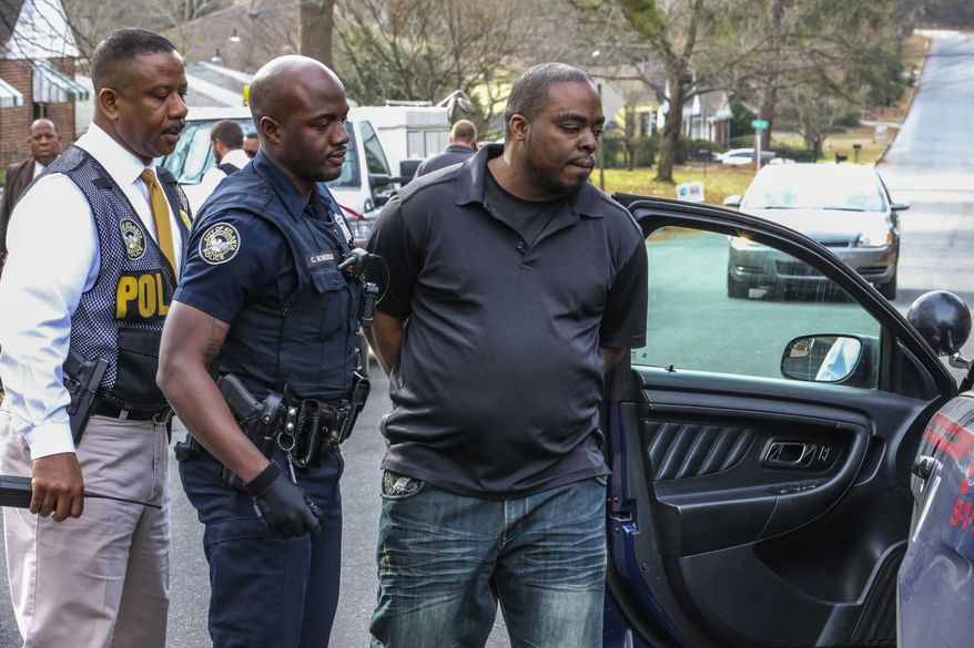 A man who police say is the owner of two pit bulls that killed one child and injured another is taken into custody from a home in Atlanta, Tuesday, Jan. 17, 2017. (John Spink /Atlanta Journal-Constitution via AP)