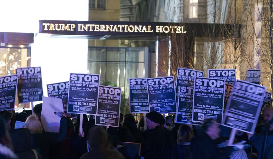 Demonstrators protest outside of the Trump Hotel during a march in downtown Washington in opposition of President-elect Donald Trump, Sunday, Jan. 15, 2017. ( AP Photo/Jose Luis Magana)