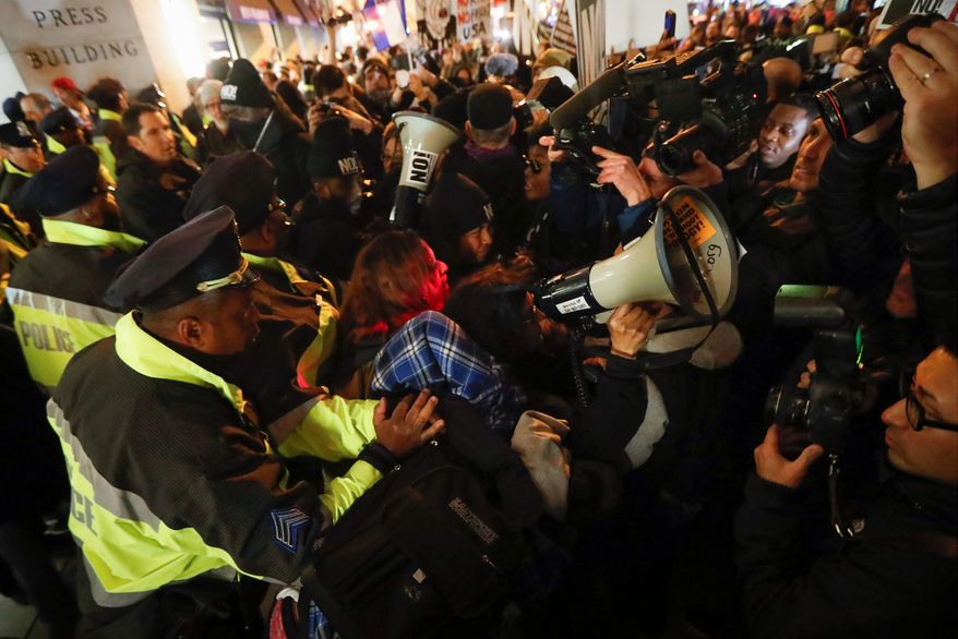 Protestors scuffle with police after refusing to vacate the sidewalk in front of the National Press Club Building ahead of the presidential inauguration, Thursday, Jan. 19, 2017, in Washington. (AP Photo/John Minchillo)