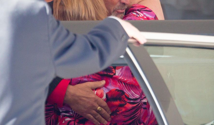 Mark Lea, of Elk River, Minn., hugs Kari Oehme during the funeral for Michael Oehme Wednesday, Jan 18, 2017, in Council Bluffs, Iowa. Oehme was killed in the Jan. 6 shooting at the Fort Lauderdale-Hollywood International Airport, in Fort Lauderdale, Fla. (Kent Sievers/Omaha World-Herald via AP)