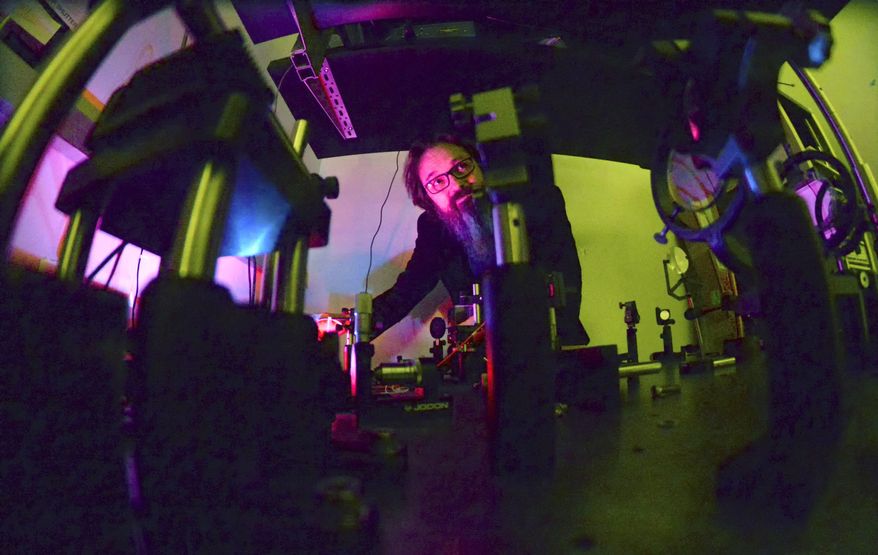 ADVANCE FOR USE SUNDAY, JAN. 22, 2017 AND THEREAFTER - In this Jan. 3, 2017 photo, Illinois Wesleyan University physics professor Gabe Spalding describes how students in his class use lasers, programmable cameras, mirrors and optics to develop devices in a campus lab for his "Momentum of the Photon" class, in Bloomington, Ill. The research being done by Spalding, has potential down-to-earth applications, from helping doctors see inaccessible parts of the body to helping motorists see through fog. (Steve Smedley/The Pantagraph via AP)