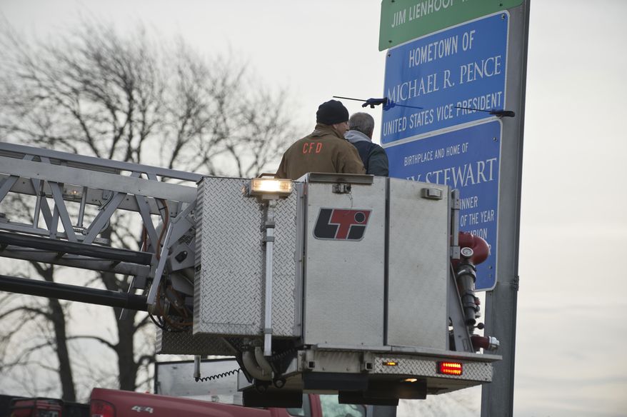 A crew from the City of Columbus drills holes to mount a sign proclaiming Columbus as the hometown of Vice President-elect Mike Pence on US-31 north of Columbus, Ind., Thursday, Jan 19, 2017. The crew drilled the holes in the sign so they could mount it easier when the put it up Friday. (Mike Wolanin/The Republic via AP)
