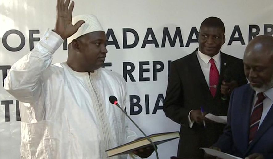 Adama Barrow is sworn in as President of Gambia at Gambia's embassy in Dakar Senegal in this image taken from TV Thursday, Jan 19, 2017. A new Gambian president has been sworn into office in neighboring Senegal, while Gambia's defeated longtime ruler refuses to step down from power, deepening a political crisis in the tiny West African country.(RTS via AP)