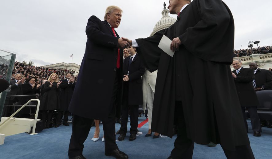 President Donald Trump shakes hands with Chief Justice John Roberts after taking the oath of office Friday, Jan. 27, 2017 on Capitol Hill in Washington. (Jim Bourg/Pool Photo via AP)