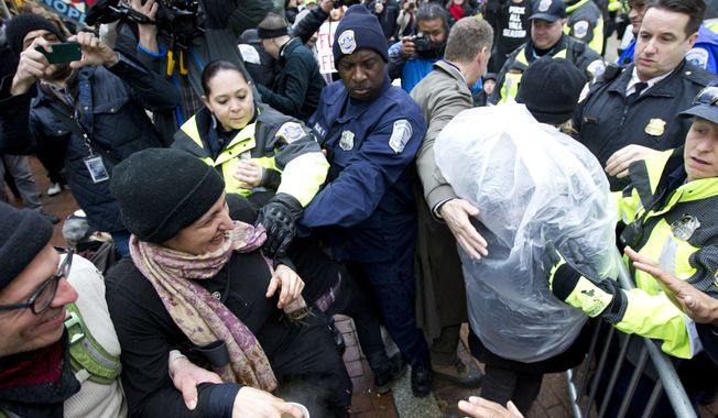 Police officers push back demonstrators attempting to block people entering a security checkpoint, Friday, Jan. 20, 2017, ahead of President-elect Donald Trump&#x27;s inauguration in Washington. ( AP Photo/Jose Luis Magana)