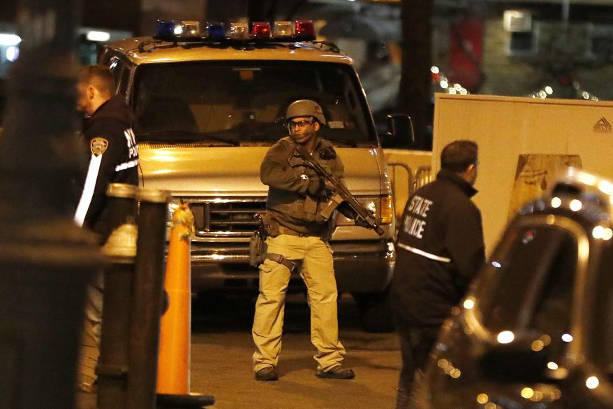 An armed officer stands guard moments before a motorcade carrying Mexican drug kingpin Joaquin "El Chapo" Guzman arrived at the Metropolitan Correctional Center in New York, Thursday, Jan. 19, 2017. The infamous drug kingpin who twice escaped from maximum-security prisons in Mexico was extradited at the request of the U.S. to face drug trafficking and other charges, and landed in New York late Thursday, a federal law enforcement official said. (AP Photo/Julio Cortez)