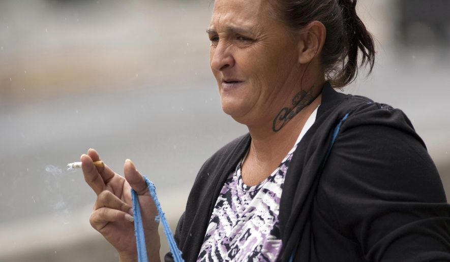 FILE - In this May 3, 2016 file photo, Samantha Watanabe stands outside federal court in Honolulu. U.S. District Court Judge Leslie Kobayashi on Friday, Jan. 20, 2017 overturned the conviction and ordered a new trial for Watanabe, found guilty in 2015 of assaulting her 15-month-old daughter on a flight from Alaska. (AP Photo/Caleb Jones, File)