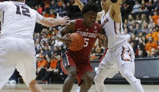 Stanford&#x27;s Kodye Pugh, center, is guarded by Oregon State&#x27;s Drew Eubanks, left, and JaQuori McLaughlin, right, during the first half of an NCAA college basketball game in Corvallis, Ore., Thursday, Jan. 19, 2017. (AP Photo/Timothy J. Gonzalez)
