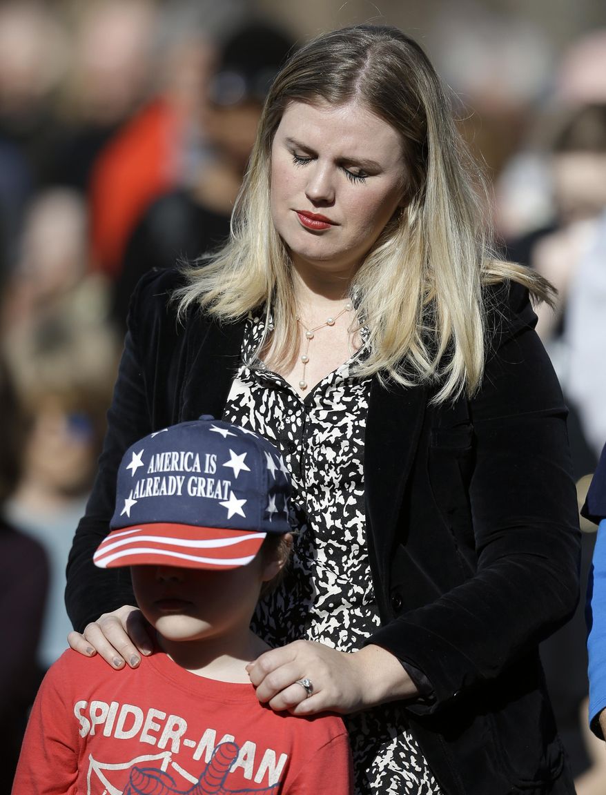 Trisha Farmer, and her son, Tyler, 7, pray during a protest against Donald Trump, Friday, Jan. 20, 2017, in Nashville, Tenn. The protesters observed 15 minutes of silence during the time Trump took the Presidential oath of office in Washington. (AP Photo/Mark Humphrey)