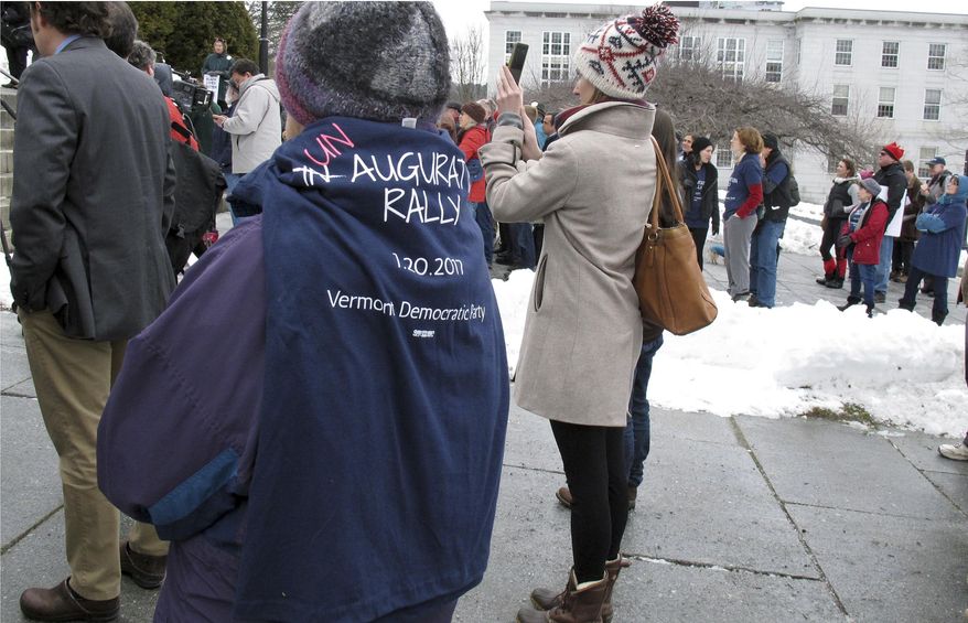 A woman wears a T-shirt commemorating an "Un-augural Rally" on Friday, Jan. 20, 2017, in Montpelier, Vt., to protest the inauguration of President Donald Trump in Washington. About 100 activists gathered on the steps of the Vermont Statehouse for the protest. (AP Photo/Wilson Ring)