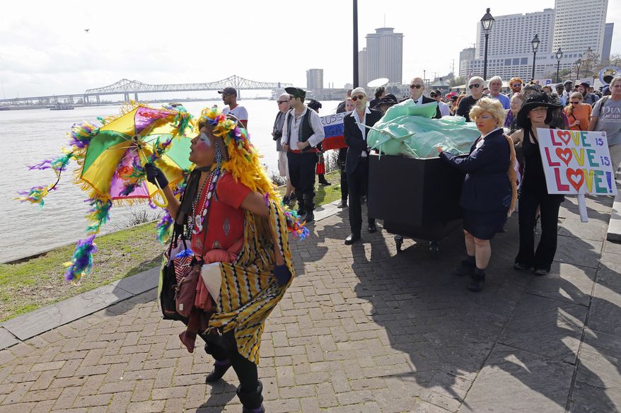 Protesters carry a coffin containing The Statue of Liberty down the streets of New Orleans in protest against Trump's inauguration in Friday, Jan. 20, 2017. (AP Photo/Max Becherer)