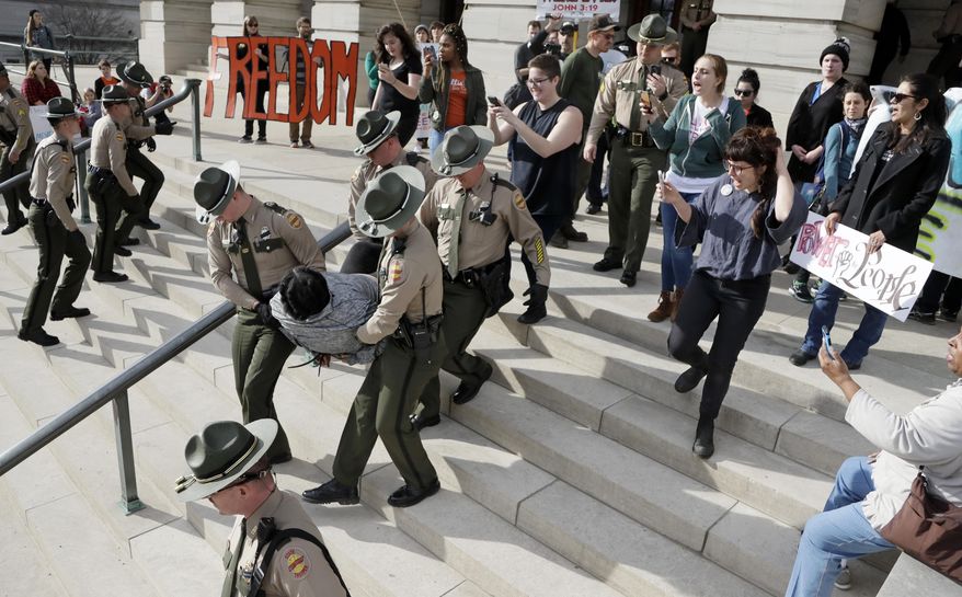 A protester is carried away from the state Capitol building Friday, Jan. 20, 2017, in Nashville, Tenn. Protesters chained themselves together and to the building as they demonstrated against the inauguration of President Donald Trump and other social issues. (AP Photo/Mark Humphrey)