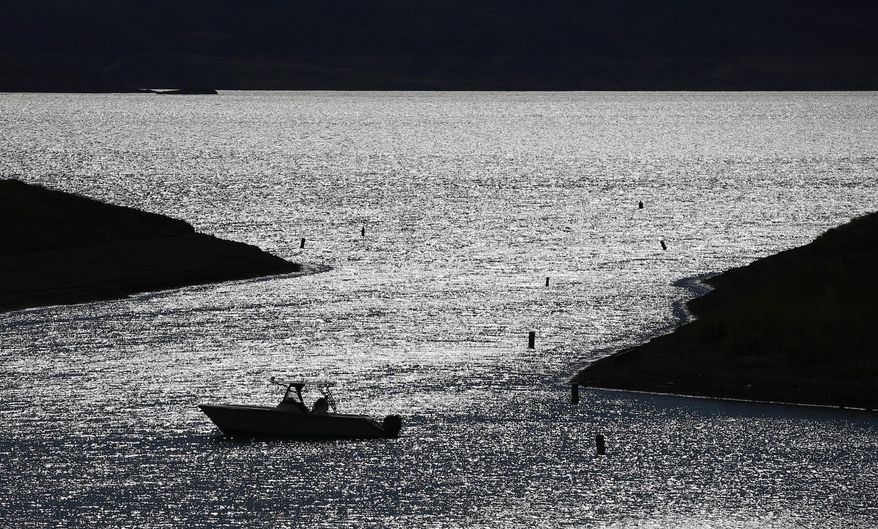 FILE--In this May 19, 2016, file photo, a boater drifts toward a boat ramp in an area that was once underwater at the Lake Mead National Recreation Area near Las Vegas, Nev. In a new report about an ongoing problem, an advocacy group is trying to project the effects in areas that depend on the Colorado River if the water level continues to fall at drought-stricken Lake Mead. (AP Photo/John Locher, File)