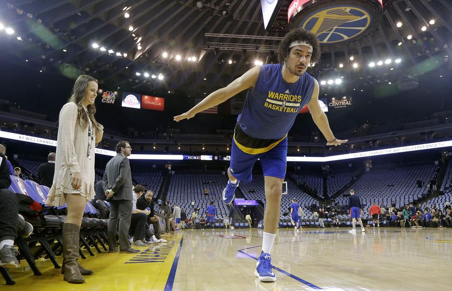 In this Jan. 12, 2017 photo, Golden State Warriors forward Anderson Varejao, right, demonstrates a yoga position while posing for photographs as yoga instructor and Warriors director of corporate communications Lisa Goodwin watches before an NBA basketball game between the Warriors and the Detroit Pistons in Oakland, Calif. Warriors head coach Steve Kerr gave Golden State a day off from the practice floor one day last week so they could practice yoga instead. (AP Photo/Jeff Chiu)