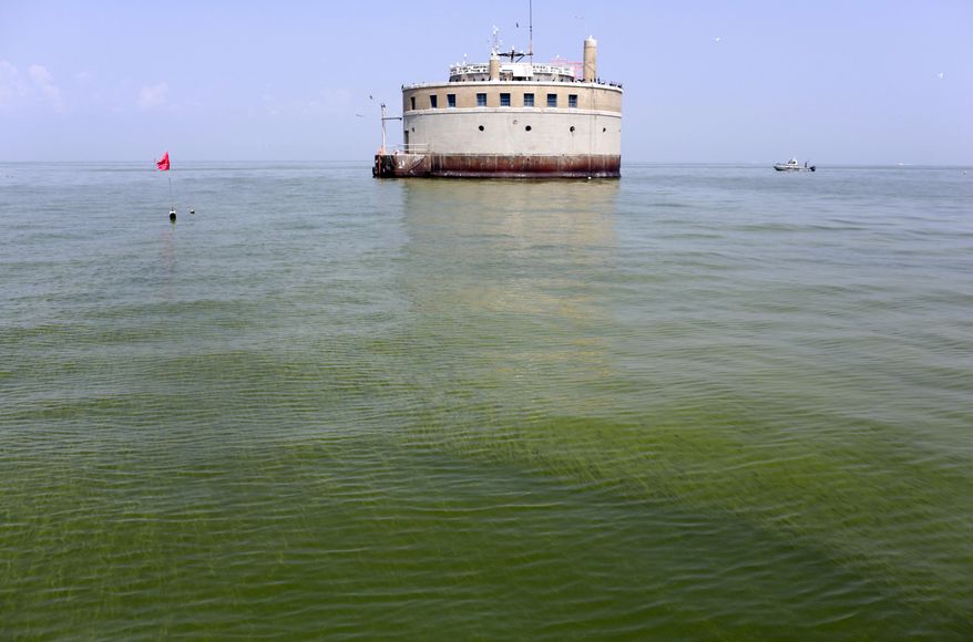 FILE – In this Aug. 3, 2014, file photo, the water intake crib for the city of Toledo, Ohio, is surrounded by an algae bloom on Lake Erie, about 2.5 miles off the shore of Curtice, Ohio. As of early 2017, about 12,000 farmers and fertilizer applicators have completed Ohio's three-hour training program that soon will be required to use commercial fertilizer. The first-of-its-kind requirement, approved by Ohio lawmakers in 2014, is one step the state has taken to reduce farm runoff that feeds toxic algae in lakes and rivers. (AP Photo/Haraz N. Ghanbari, File)