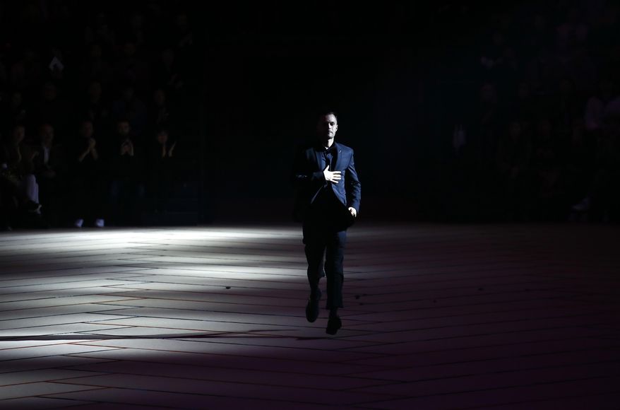 Belgian art director Kris van Assche acknowledges applause after the presentation of Christian Dior's Men fall-winter 2017-2018 fashion collection presented in Paris, Saturday, Jan. 21, 2017. (AP Photo/Francois Mori)