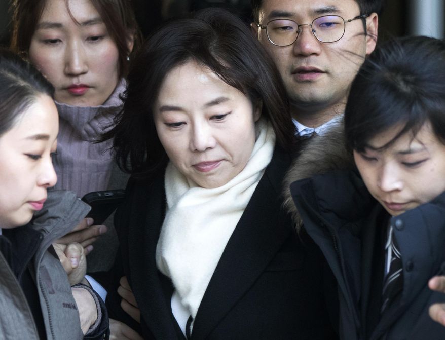 In this Friday, Jan. 20, 2017 photo, South Korean Culture Minister Cho Yoon-sun, center, leaves the Seoul Central District Court in Seoul, South Korea, after attending a hearing. South Korean prosecutors on Saturday, Jan. 21, arrested Cho and President Park Geun-hye's former top presidential adviser over allegations that they blacklisted artists critical of the government. (Choi Jae-koo/Yonhap via AP)