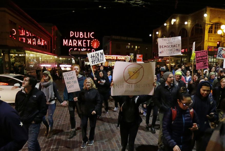 Protesters march near Pike Place Market during a march against President Donald Trump, Friday, Jan. 20, 2017, in Seattle. (AP Photo/Ted S. Warren)