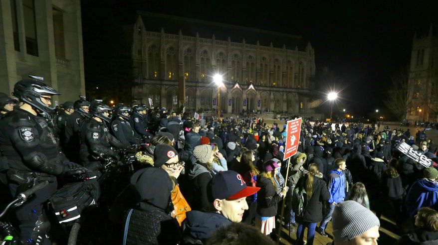 Protesters and police gather in front of Kane Hall on the University of Washington campus where far-right commentator Milo Yiannopoulos was giving a speech, Friday, Jan. 20, 2017, in Seattle. (AP Photo/Ted S. Warren)