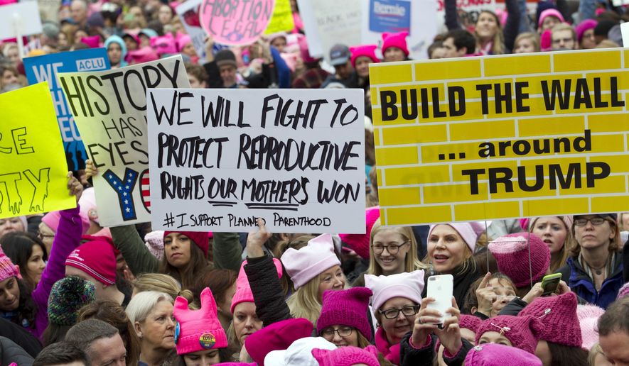 Women with bright pink hats and signs begin to gather early and are set to make their voices heard on the first full day of Donald Trump&#39;s presidency, Saturday, Jan. 21, 2017, in Washington. (AP Photo/Jose Luis Magana) ** FILE **