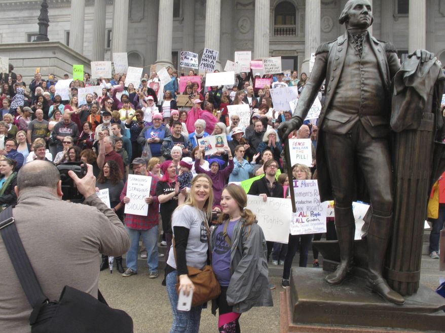 Thousands of women gather for the Stand Up Rally for women and minority rights on Saturday, Jan. 21, 2017, at the Statehouse in Columbia, S.C.. Similar rallies were being held across the country to protest President Donald Trump and his administration. (AP Photo/Jeffrey Collins)
