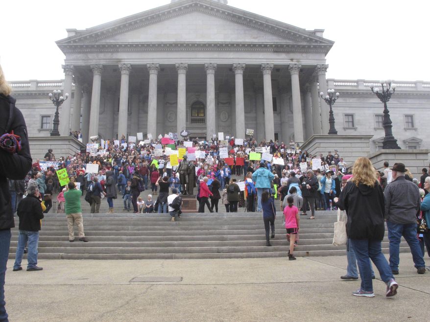 Thousands of women gather for the Stand Up Rally for women and minority rights on Saturday, Jan. 21, 2017, at the Statehouse in Columbia, S.C. Similar rallies were being held across the country to protest President Donald Trump and his administration. (AP Photo/Jeffrey Collins)