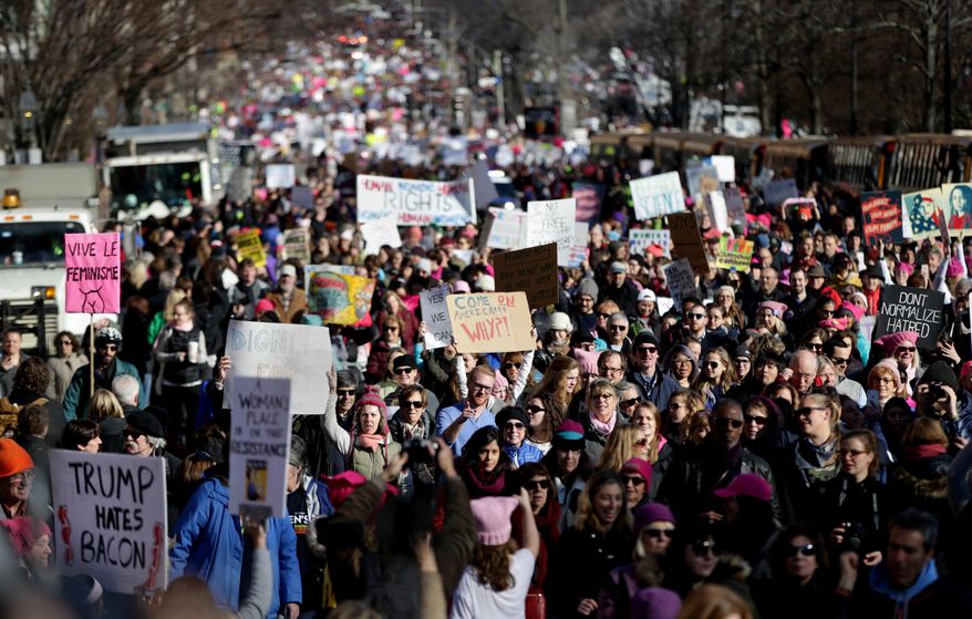 Protesters head down Beacon Street during a Women's March Saturday Jan. 21, 2017 in Boston. The march is being held in solidarity with similar events taking place in Washington and around the nation. ( Jonathan Wiggs/The Boston Globe via AP)