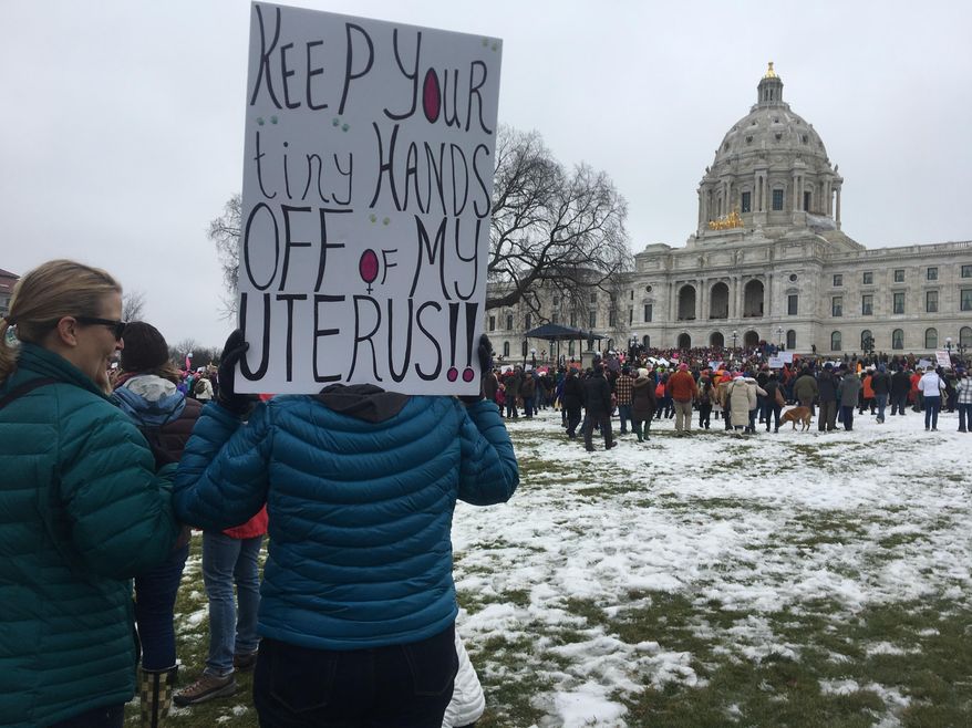 A protester holds sign at Minnesota Women's March in St. Paul, Minn., on Saturday, Jan. 21, 2017. The march was held in in conjunction with with similar events taking place around the nation following the inauguration of President Donald Trump. (AP Photo/Jeff Baenen)