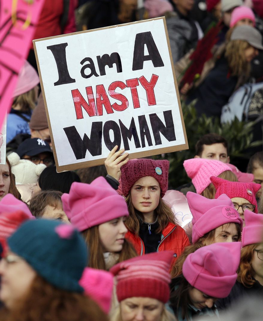 A woman holds a sign amidst a sea of pink caps before a women's march Saturday, Jan. 21, 2017, in Seattle. Women across the Pacific Northwest marched in solidarity with the Women's March on Washington and to send a message in support of women's rights and other causes. (AP Photo/Elaine Thompson)