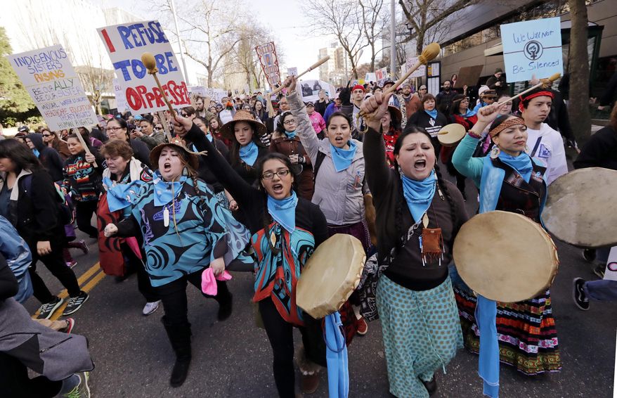 Native American women singers and drummers lead a women's march of thousands as it arrives at the Seattle Center, Saturday, Jan. 21, 2017, in Seattle. Women across the Pacific Northwest marched in solidarity with the Women's March on Washington and to send a message in support of women's rights and other causes. (AP Photo/Elaine Thompson)