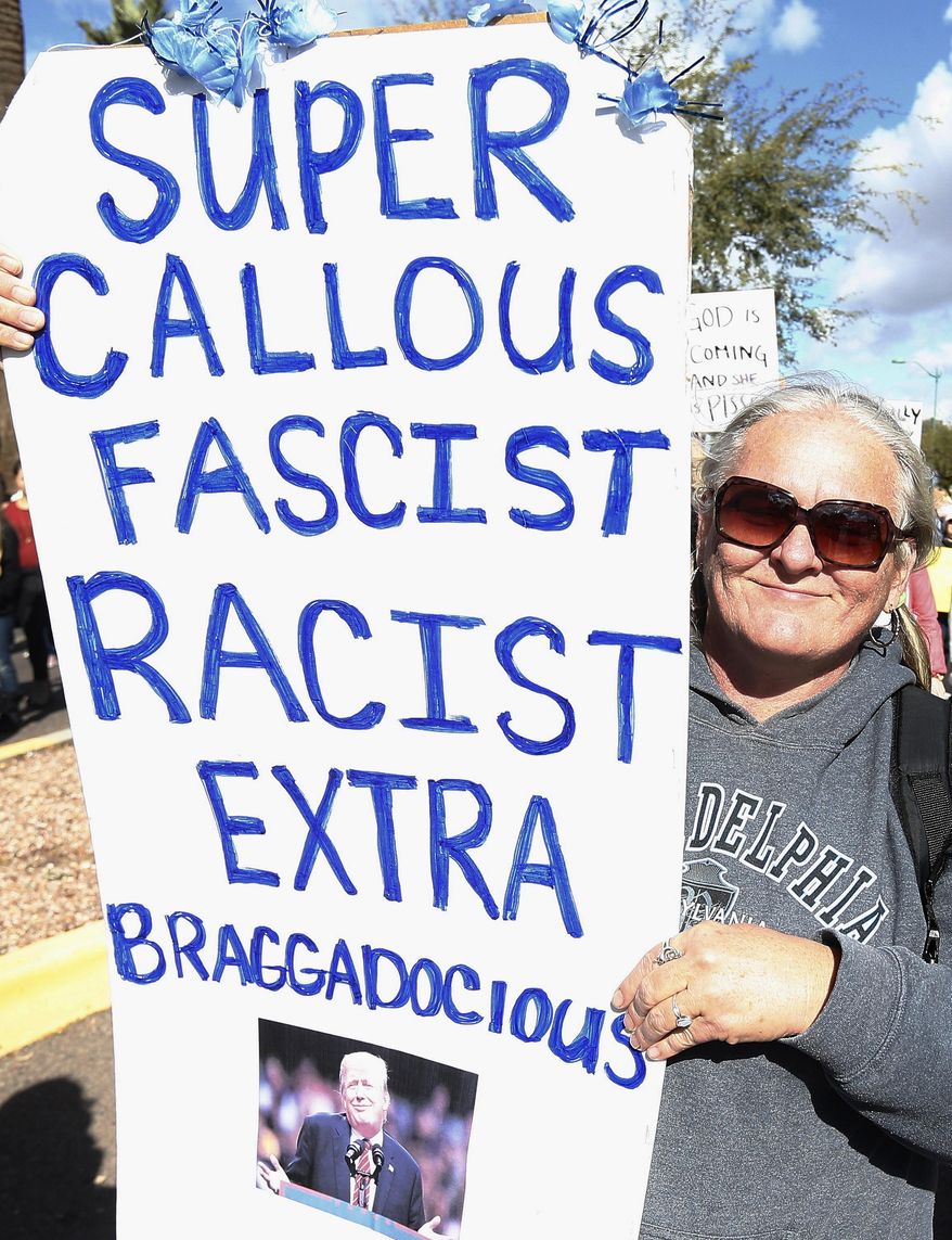 A demonstrator holds a sign and marches in support of the Women's March on Washington Saturday, Jan. 21, 2017, in Phoenix. Thousands of protesters in Phoenix joined in support of those in cities around the globe protesting against Donald Trump as the new United States president. (AP Photo/Ross D. Franklin)