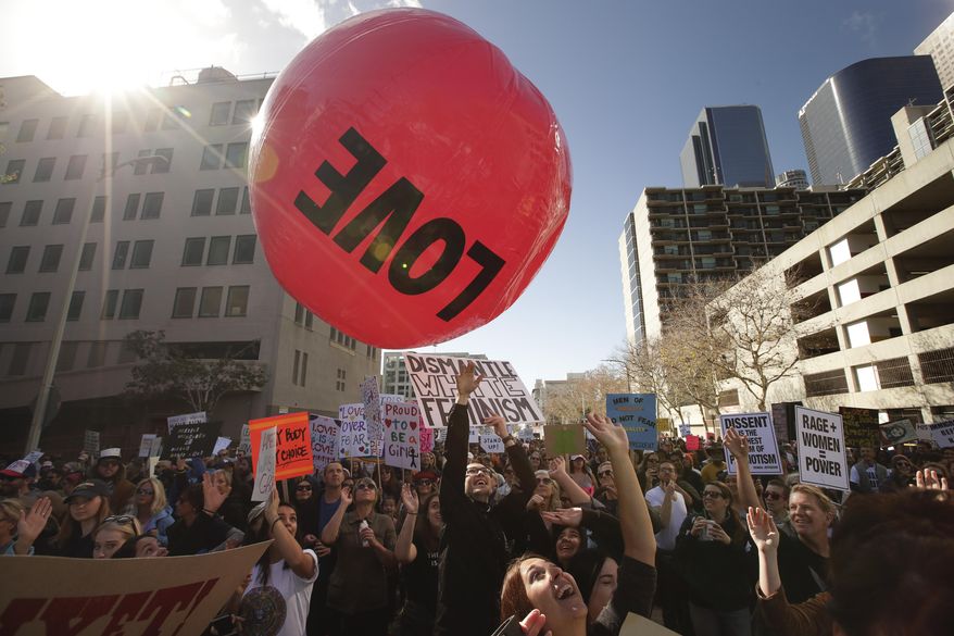A group of protesters toss the inflated ball around while marching along the street at the Women's Protest against President Donald Trump Saturday, Jan. 21, 2017, in Los Angeles. The march was held in in conjunction with with similar events taking place around the nation following the inauguration of Trump. (AP Photo/Jae C. Hong)
