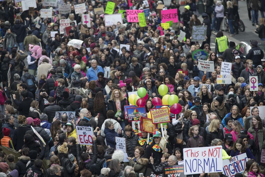 Demonstrators march across 42nd Street during a women's march, Saturday, Jan. 21, 2017, in New York. The march is being held in solidarity with similar events taking place in Washington and around the nation. (AP Photo/Mary Altaffer)