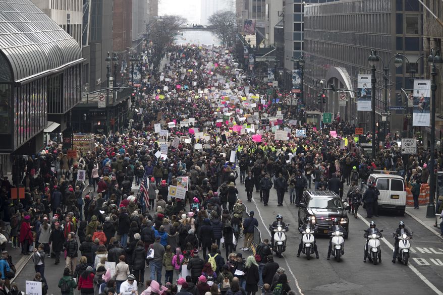 New York City police officers lead the demonstrators as they march across 42nd Street during a women's march in New York, Saturday, Jan. 21, 2017. The march is being held in solidarity with similar events taking place in Washington and around the nation. (AP Photo/Mary Altaffer)