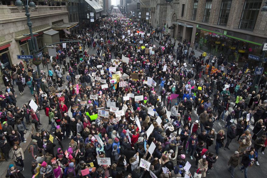 Demonstrators march across 42nd Street during a women's march, Saturday, Jan. 21, 2017, in New York. The march is being held in solidarity with similar events taking place in Washington and around the nation.(AP Photo/Mary Altaffer)