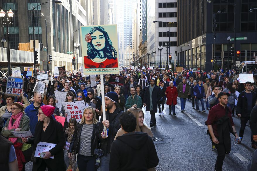 Protesters walk along North LaSalle Street during the Women's March on Chicago the day after President Donald Trump's inauguration Saturday, Jan. 21, 2017 in Chicago. (Armando L. Sanchez/Chicago Tribune via AP)