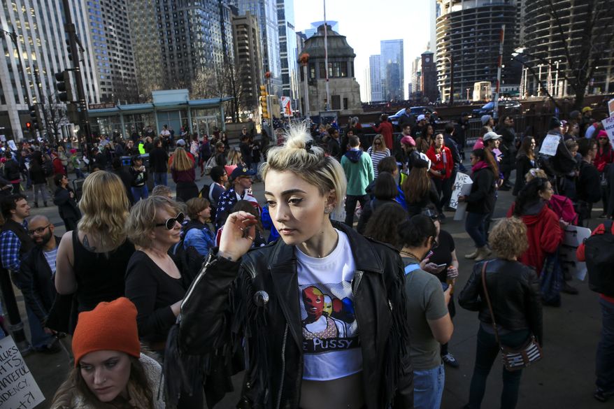 Rosebud Doetsch, 20, looks out at the crowd near the intersection of West Wacker Drive and North Wabash Avenue during the Women's March on Chicago the day after President Donald Trump's inauguration Saturday, Jan. 21, 2017 in Chicago. (Armando L. Sanchez/Chicago Tribune via AP)