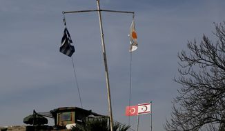 Greek and Cypriot flags fly next to a Turkish military guard post with Turkish and Turkish Cypriot breakaway flags between U.N. buffer zone. After decades of frustration, intensive talks between leaders of the Greek and Turkish Cypriot communities have created a sense of optimism to heal political divisions. (Associated Press)