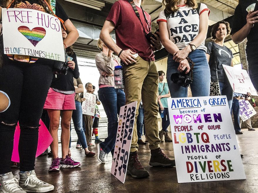 In a Saturday, Jan. 21, 2017 photo, people hold signs at the Gulf Coast Solidarity Rally at Cafe Climb in Gulfport, Miss., before their Women&#39;s March. About 300 people attended the event held in conjunction with the Women&#39;s March in Washington D.C. (Justin Mitchell/The Sun Herald via AP)