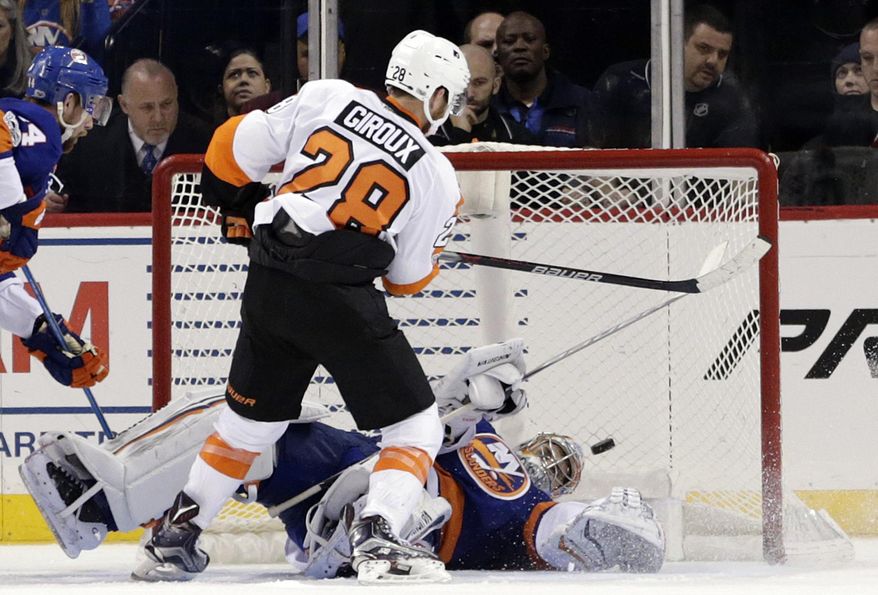 Philadelphia Flyers' Claude Giroux, left, scores the winning goal past New York Islanders goalie Thomas Greiss during overtime of the NHL hockey game, Sunday, Jan. 22, 2017, in New York. The Flyers defeated the Islanders in overtime 3-2. (AP Photo/Seth Wenig)