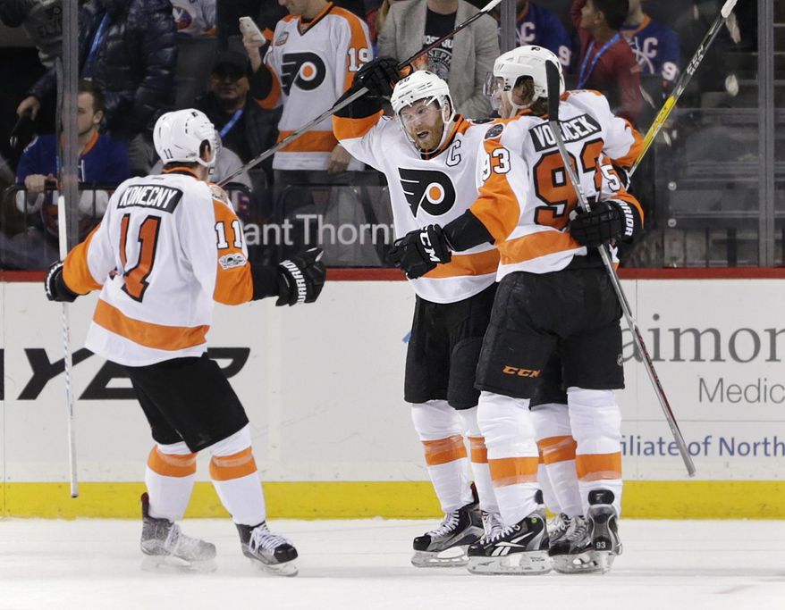 Philadelphia Flyers' Claude Giroux, second from left, celebrates with teammates after scoring the winning goal in the overtime period of the NHL hockey game against the New York Islanders, Sunday, Jan. 22, 2017, in New York. The Flyers defeated the Islanders in overtime 3-2. (AP Photo/Seth Wenig)