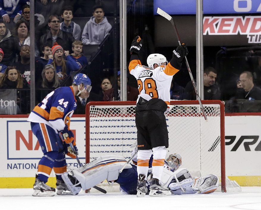 Philadelphia Flyers' Claude Giroux, top, reacts after scoring the winning goal past New York Islanders goalie Thomas Greiss during overtime of the NHL hockey game, Sunday, Jan. 22, 2017, in New York. The Flyers defeated the Islanders in overtime 3-2. (AP Photo/Seth Wenig)