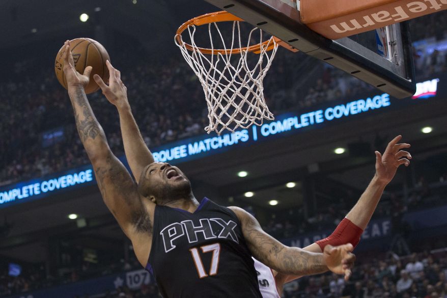 Phoenix Suns' P.J. Tucker (17) jumps for a rebound with Toronto Raptors' Jonas Valanciunas during first half NBA basketball action in Toronto on Sunday, Jan. 22, 2017. (Chris Young/The Canadian Press via AP)