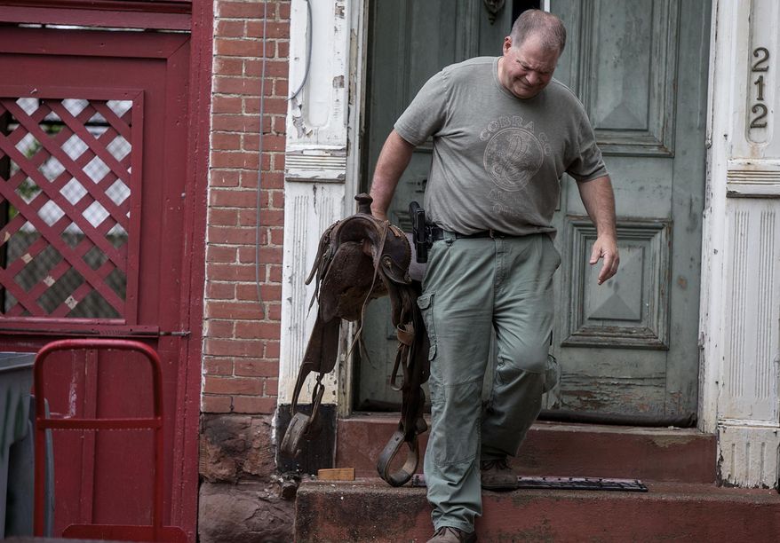 FILE – In this June 2, 2015 file photo, an investigator carries a saddle while removing Western artifacts from the home of former Harrisburg, Pa., Mayor Stephen Reed in Harrisburg, Pa. Jury selection is set to begin Monday, Jan. 23, 2017, in the criminal case against Reed, charged with receiving stolen property after spending millions in public funds to buy artifacts for a Wild West museum that was never built. His lawyer says Reed didn't steal anything and was in lawful possession of the items. (Sean Simmers/PennLive.com via AP, File)