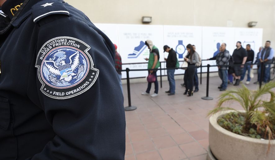 Pedestrians crossing from Mexico into the United States at the Otay Mesa Port of Entry wait in line Thursday, Dec. 10, 2015, in San Diego. (AP Photo/Denis Poroy)