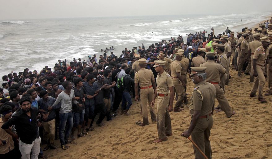 Protestors supporting Jallikattu, a traditional bull-taming ritual try to form a human chain as police try to remove them from the Marina beach on the Bay of Bengal coast in Chennai, India, Monday, Jan.23, 2017. Protestors attacked a police station with stones and set some vehicles on fire Monday in anger at being forcibly evicted from the beach where they been protesting for the past week in support of the sport. Jallikattu involves releasing a bull into a crowd of people who attempt to grab it and ride it. It is popular in Tamil Nadu state, but India&#39;s top court banned it in 2014 on grounds of animal cruelty. (AP Photo)